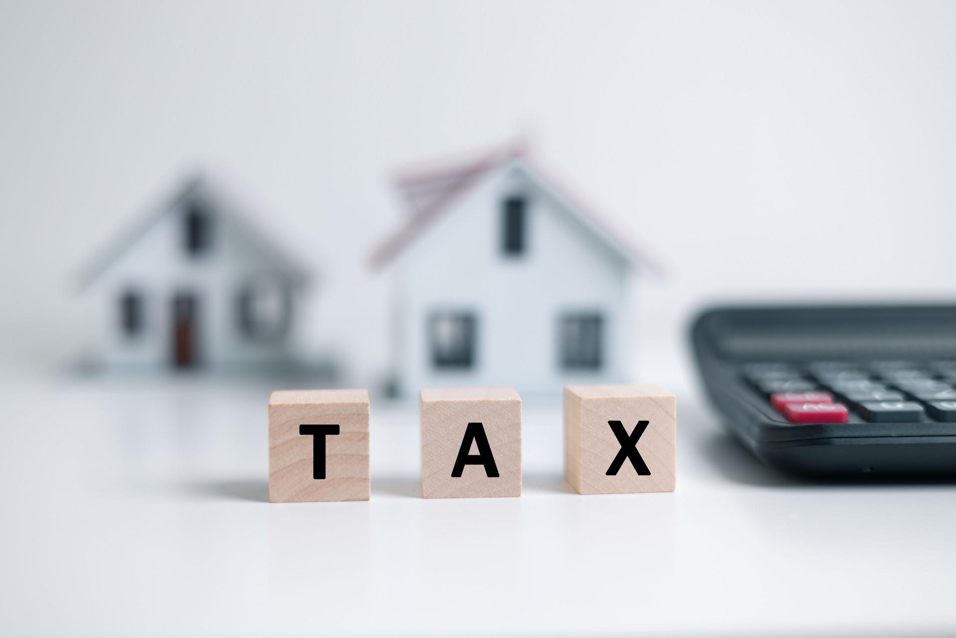 Concept of paying state property tax. Property Tax Wooden Blocks With A Miniature House. house model, mortgage loading real estate property with loan money bank concept.Home sales and home insurance